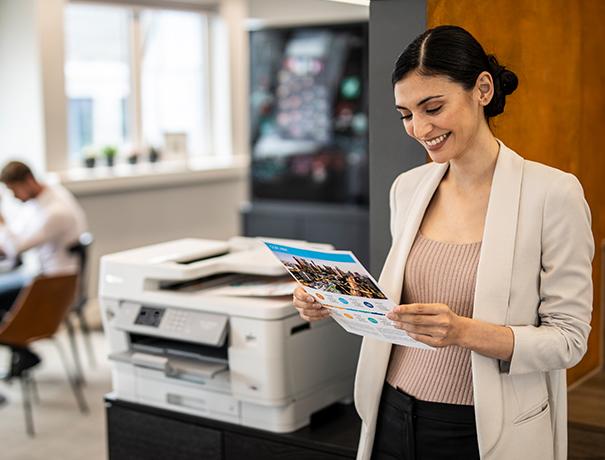 Worker checking image quality from A3 business inkjet device