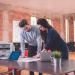 Colleagues discussing work at a desk.
